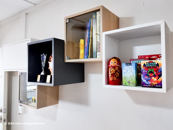 Black, oak and white EKET cube shelving units mounted on a wall in the living room of a 3-room HDB flat in Singapore, designed by IKEA Home design service