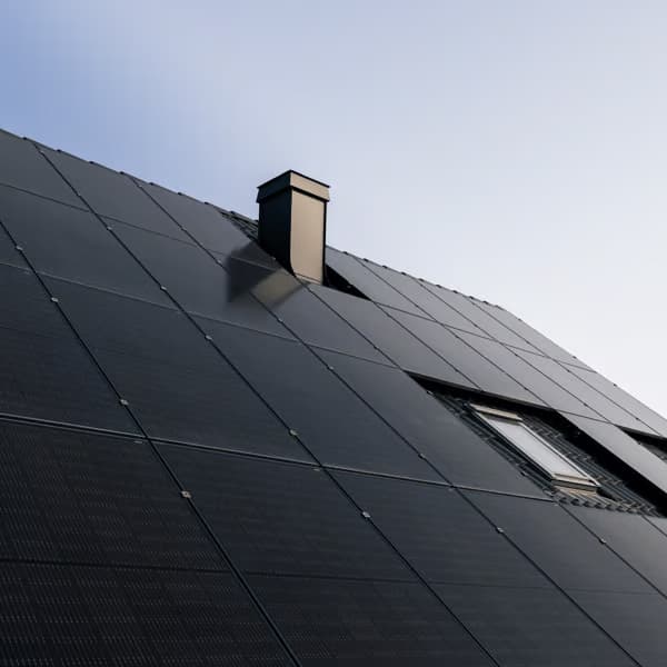 Black solar panels on the roof oh a home.