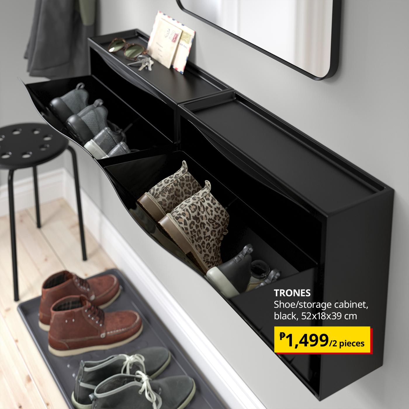 Black wall-mounted TRONES shoe/storage cabinet holds shoes and pillows; modern entryway display with ₱1,499/2-piece price tag.