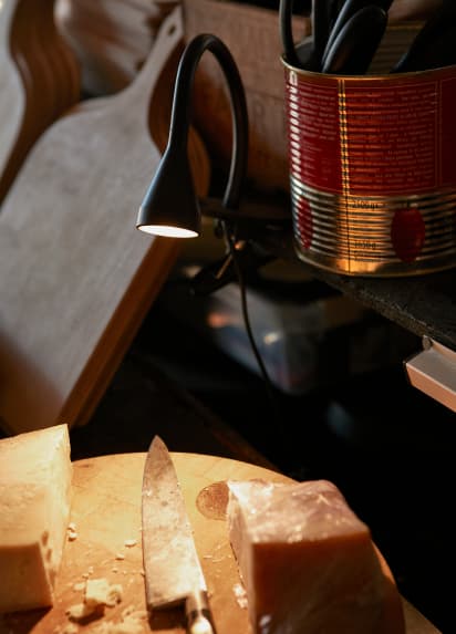 Blick auf ein großes Brett mit einem Messer und einem halben Laib Käse.