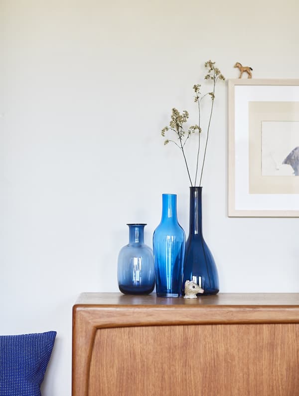 Blue vases on a wooden sideboard.