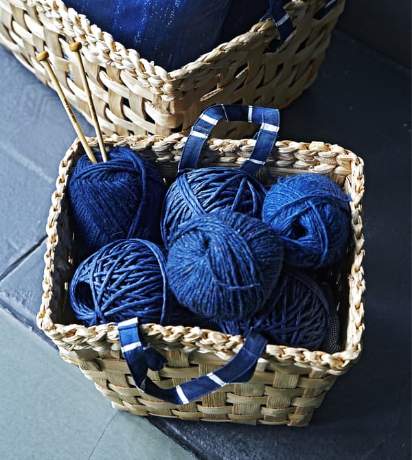 Blue yarn in a woven basket with blue handles.