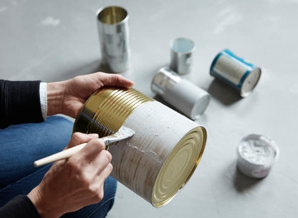 Boîtes de conserve peintes avec une pâte ressemblant à du ciment et transformées en rangements pour la cuisine