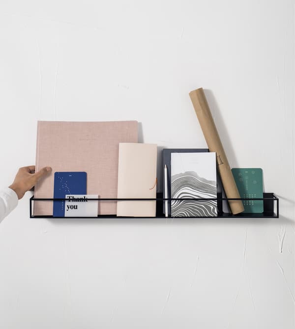 Books and stationery on a black display shelf.