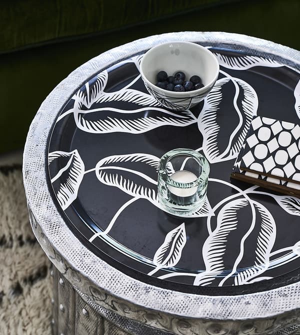 Bougie et bol sur un plateau, avec motif noir et blanc.