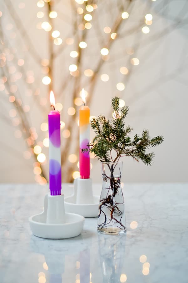Bougies décoratives colorées dans un bougeoir blanc sur une table