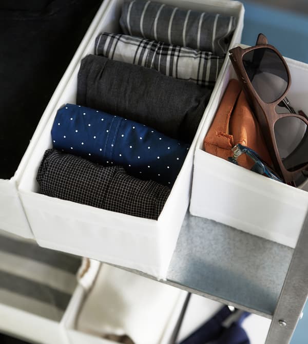 Boxes are a great way to keep smaller wardrobe accessories organized in a shelving unit.