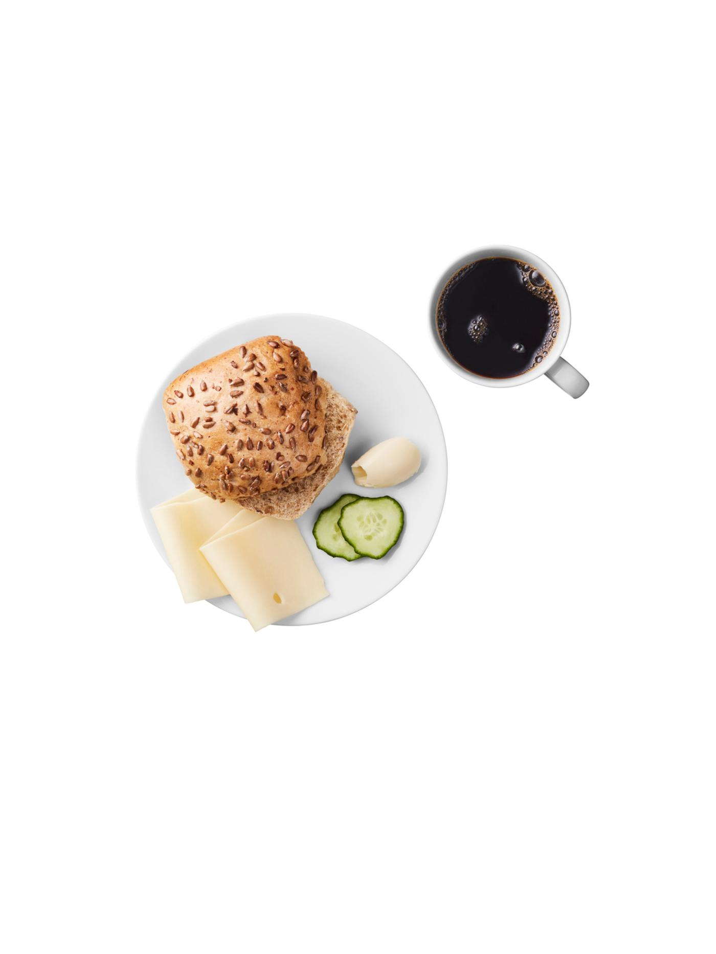 Breakfast plate with seeded bread roll, cheese slices, butter, cucumber slices, and a cup of black coffee.