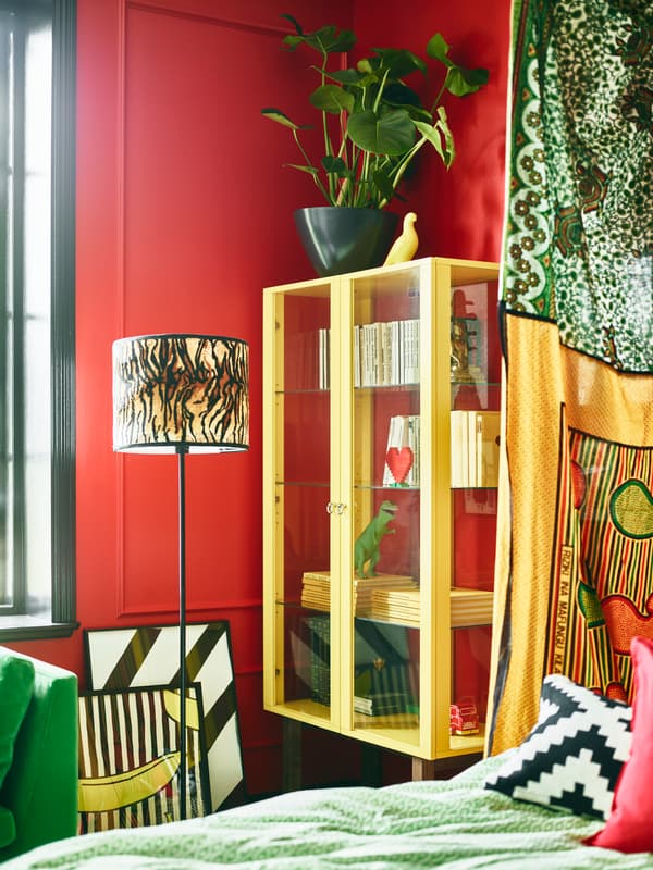 Bright coloured furniture and red walls help make this stylist’s dream bedroom.