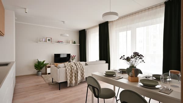 Bright open-plan living and dining area with soft neutral furnishings, dark green curtains, natural wood flooring, and large windows that fill the contemporary apartment interior with natural light and warmth.