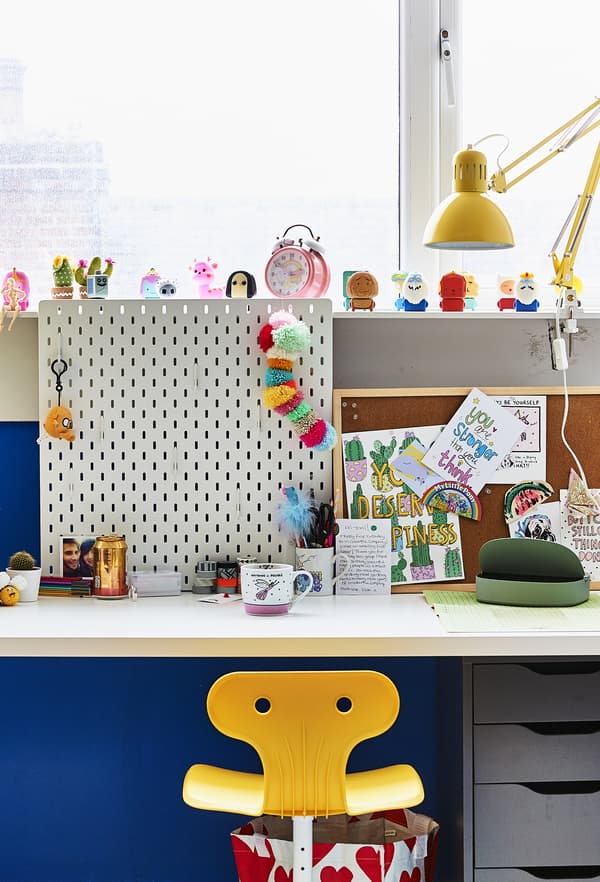 Bureau avec panneau perforé et chaise jaune.