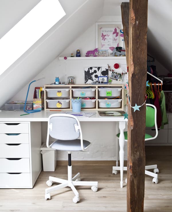 Bureau d’enfant avec boîtes de rangement et deux chaises.