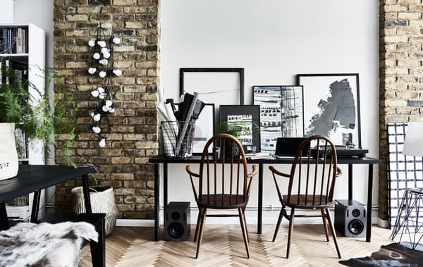 Bureau pour deux personnes, avec œuvres d’art monochromes.