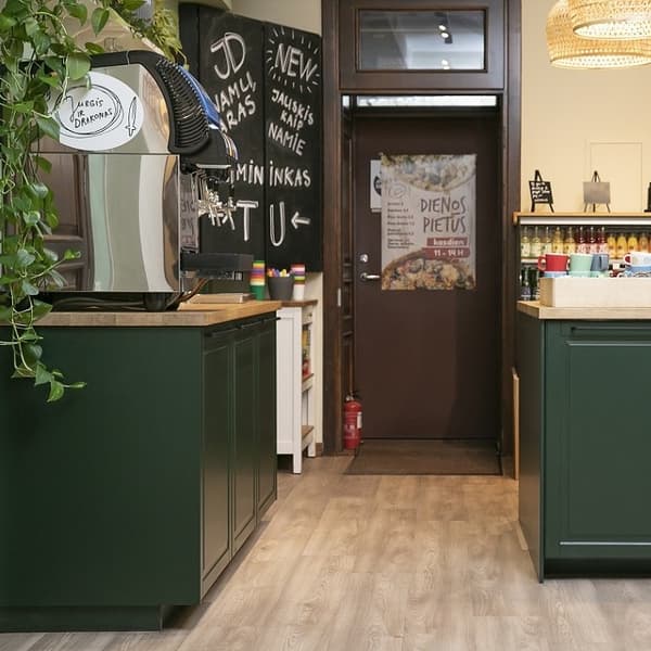 Café entrance view with coffee machine, green counters, and daily lunch menu sign.