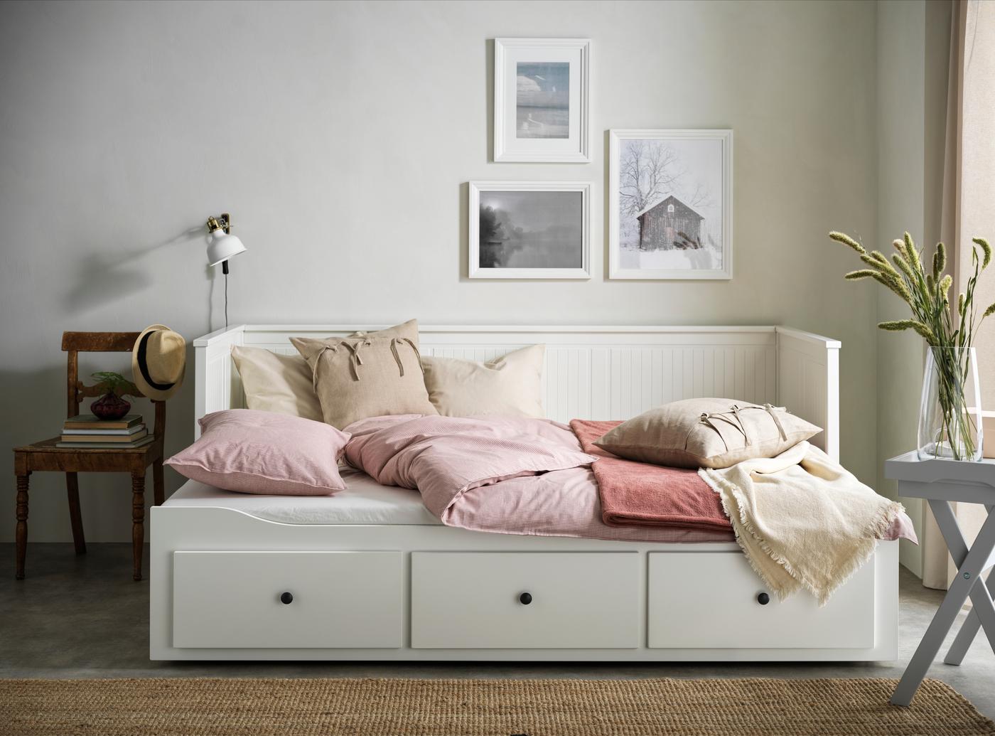Cama blanca daybed HEMNES con cojines rosados y beige