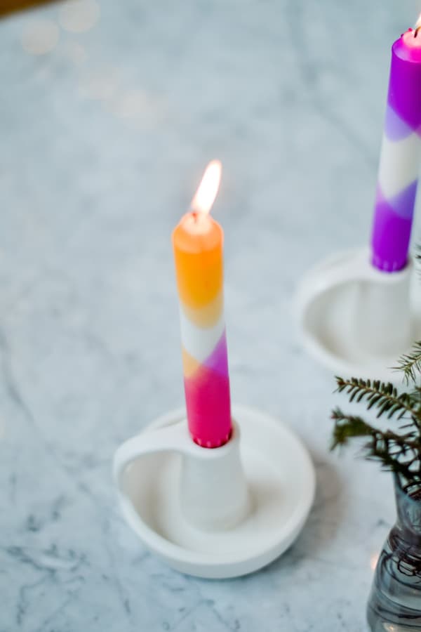Candele colorate in un portacandele bianco
