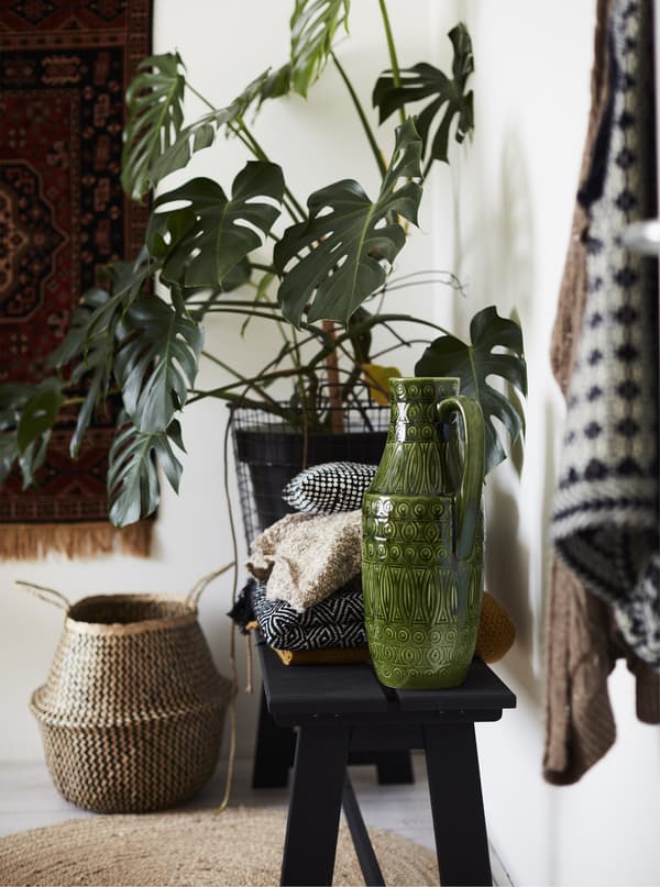 Céramiques et plantes exposées sur un banc noir.