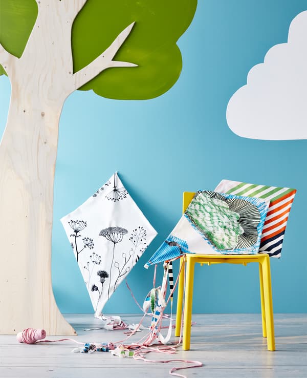 Cerf-volant bricolé posé sur une chaise, à côté d’un arbre.