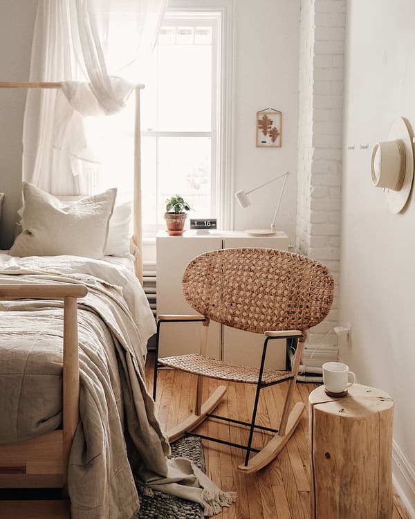 Chaise berçante rotin et frêne tissée à la main GRÖNADAL dans un coin de la chambre d’Emilie.