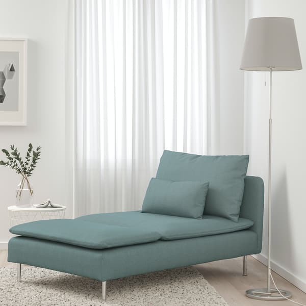 Chaise longue de color turquesa en un living con paredes de color blanco.