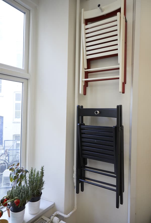 Chaises pliantes accrochées au mur.