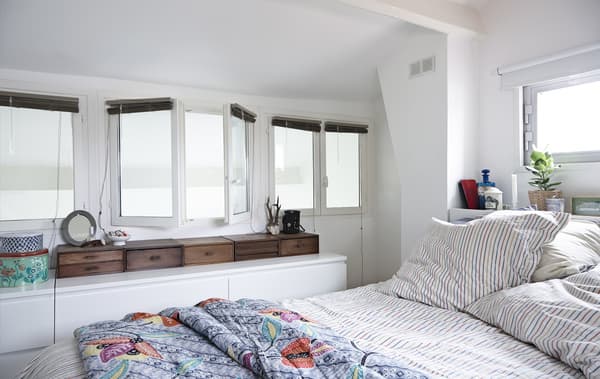 Chambre avec murs blancs et rangements intelligents