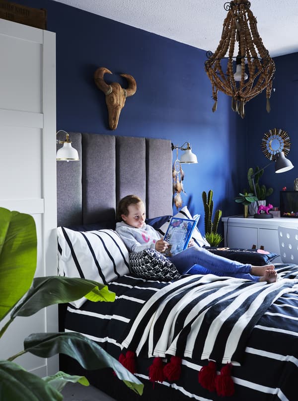 Chambre d’enfant avec murs bleus et literie monochrome.
