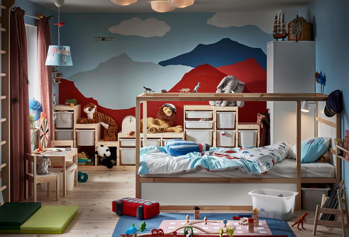 Chambre d’enfant ; sur le mur du fond, on a peint des montagnes. La chambre contient un lit réversible, un espalier, des jouets et divers systèmes de rangement.