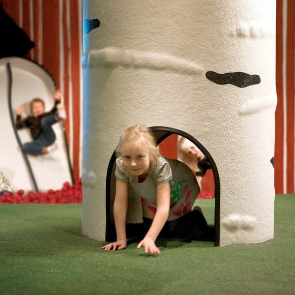 Child is playing in  Småland and crawling threw tree tunnel.
