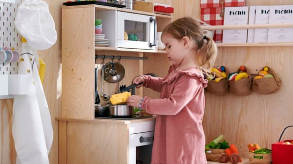 Child playing at a kid sized kitchen set