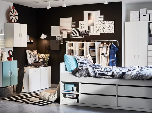Children's room in white, blue and black with a white bed frame, tiger-patterned quilt cover and pillowcase and blue details.
