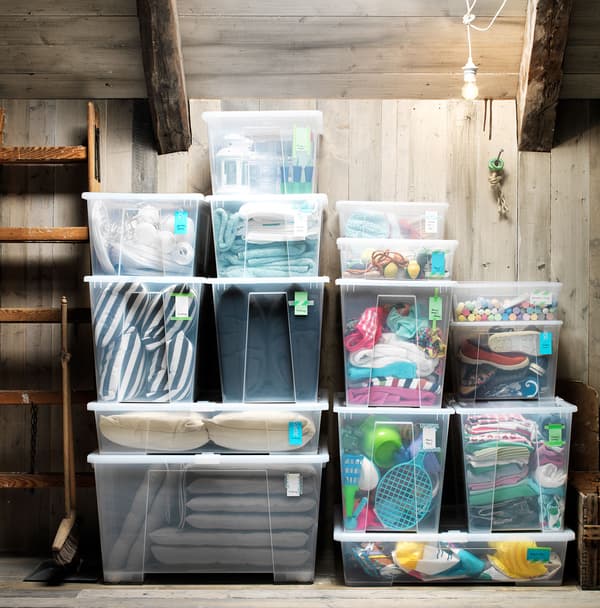 Clear SAMLA containers with lids, filled with a variety of materials, placed in an attic.