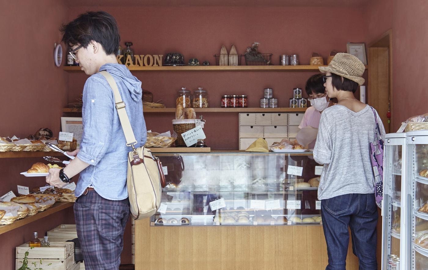 Clients en train de choisir des pains et des gâteaux dans la boulangerie.