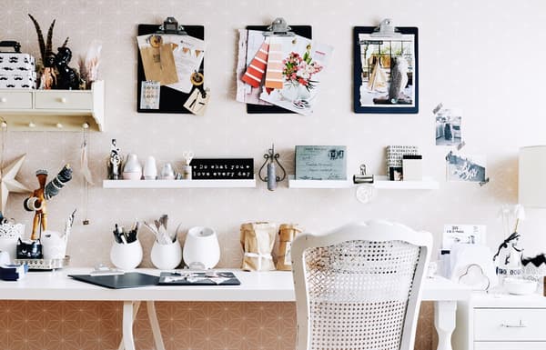 Clipboards on a wall above a desk.