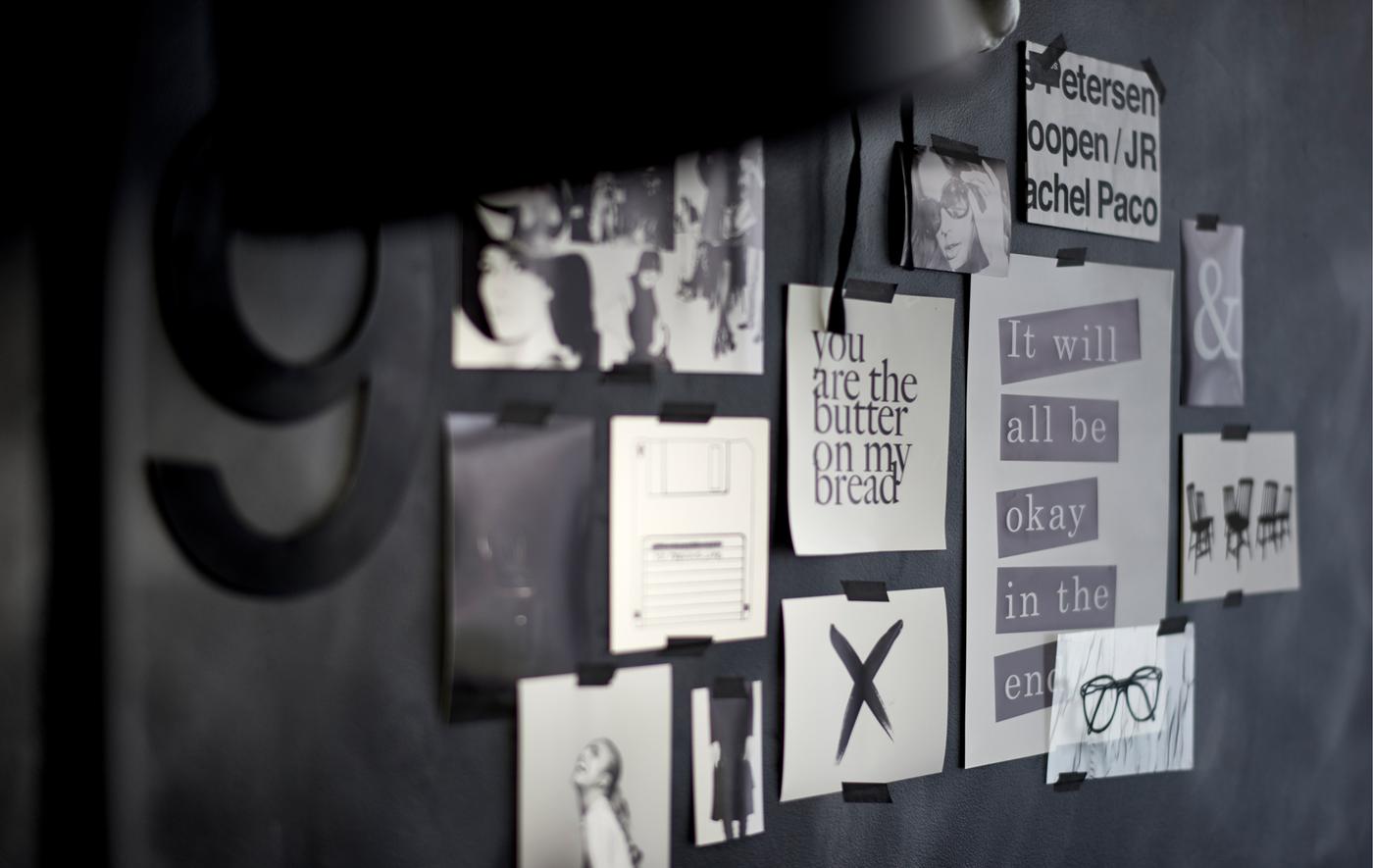 Close-up of a black-and-white inspiration board art wall with removable tape.
