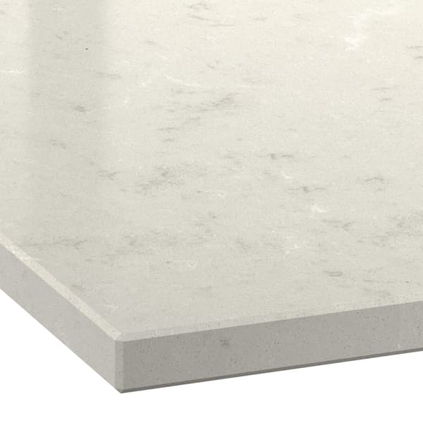 Close-up of a light beige countertop with subtle gray veining and a smooth, polished finish.