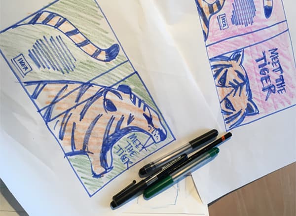 Close-up of a sketch of a tiger and some pens.