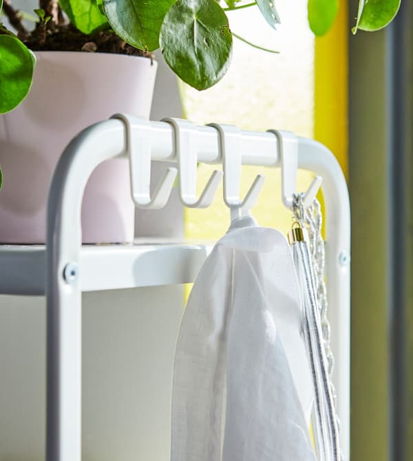 Close-up of an open shelving unit with smart hooks on the side.