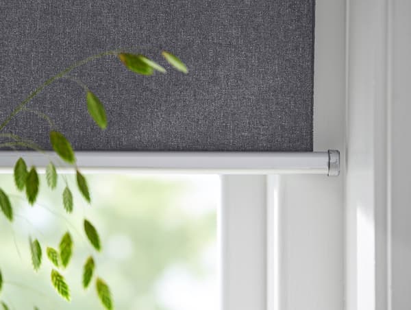 Close-up view of an IKEA smart window blind with houseplant in foreground.