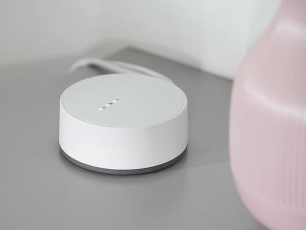 Close-up view of the TRÅDFRI gateway device on a grey tabletop.