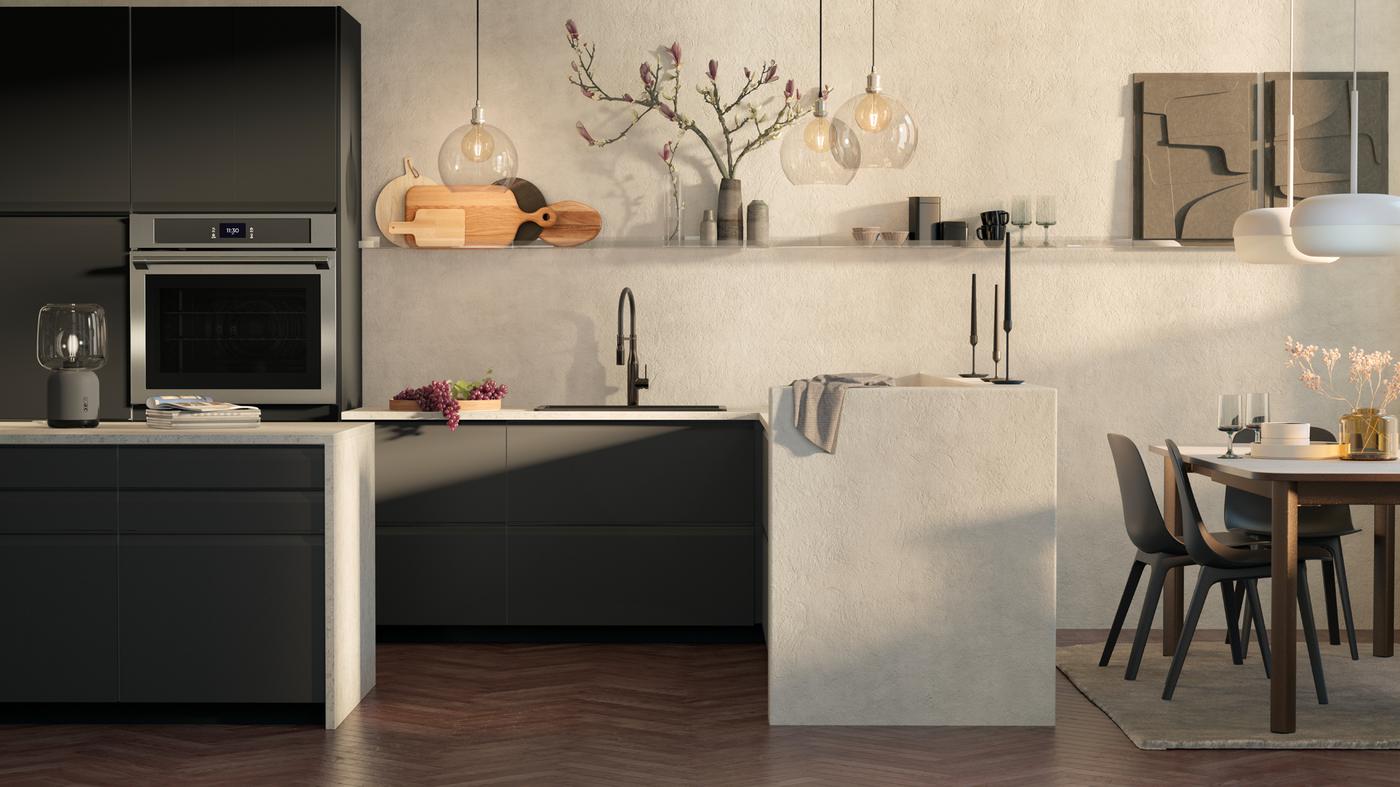 Cocina con frentes de cajón UPPLÖV de color carbón mate, una lámpara JAKOBSBYN y un horno de pared TÄNGBY de acero inoxidable.