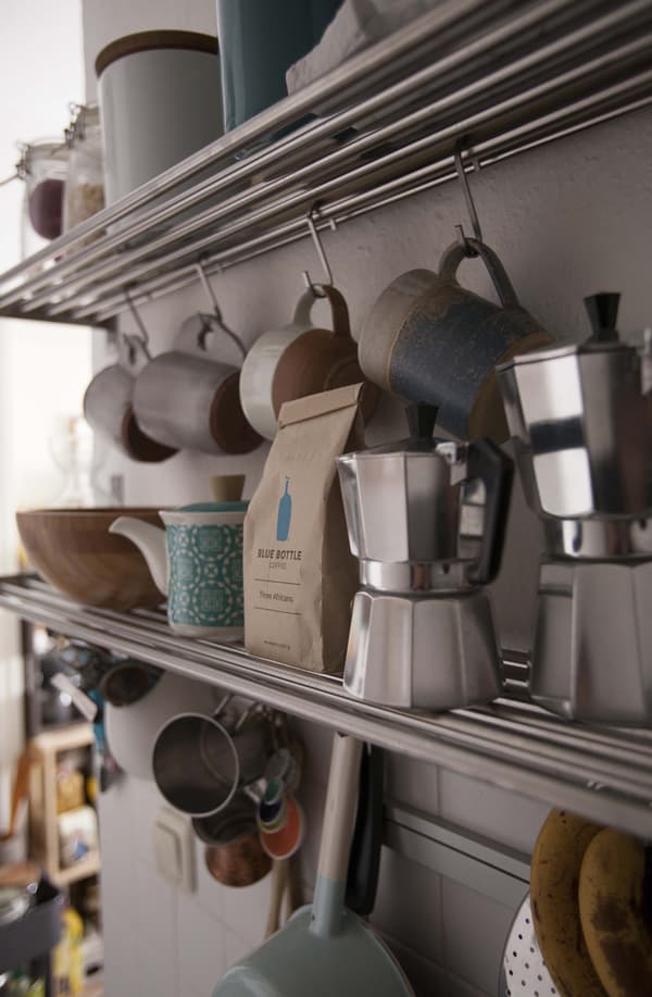 Coffee bags and coffee peculators and various cups and items on shelves.