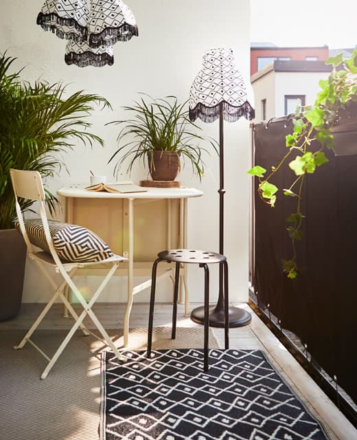 Coin détente équipé d’une table et de deux chaises. L’intimité est assurée par un coupe-vent noir.