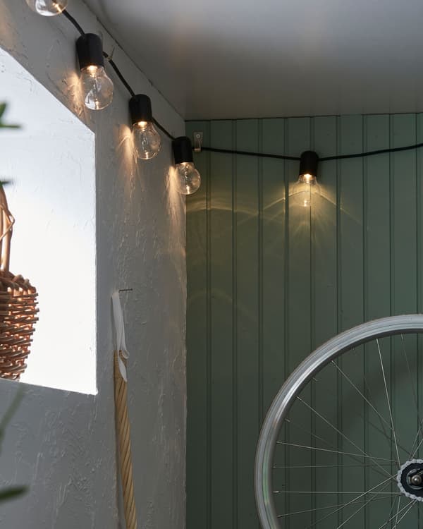 Coin d’un sous-sol ou d’un garage décoré avec des guirlandes lumineuses suspendues près du plafond.