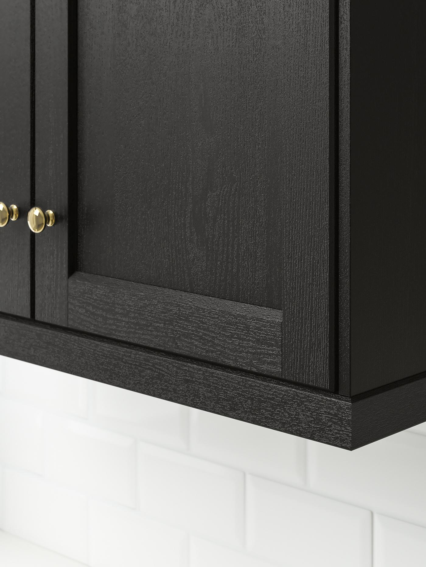 Coin inférieur d’une armoire de cuisine avec des portes LERHYTTAN teintes en noir.