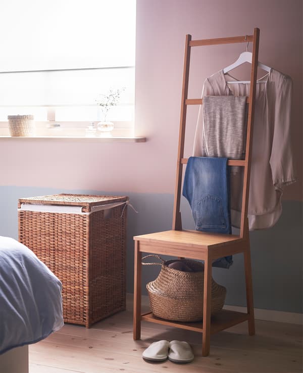Coin vêtements avec une chaise et un panier pour les vêtements encore mettables et un panier à linge pour les vêtements sales. 