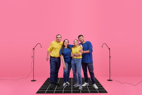 Colaboradores o trabajadores de IKEA compartiendo dentro de la tienda. Hay hombre y mujeres, vestidos con sus uniformes azules y amarillos, los colores de la bandera de Suecia. Foto de espalda.