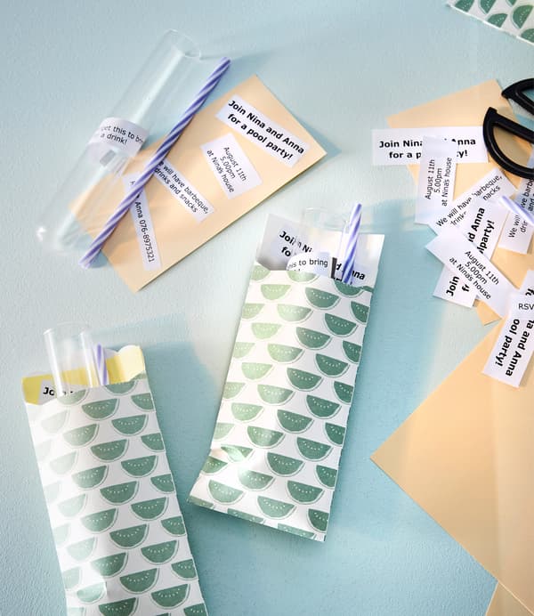 Colorful envelopes each hold glass tubes, paper straws and a small note with party information.