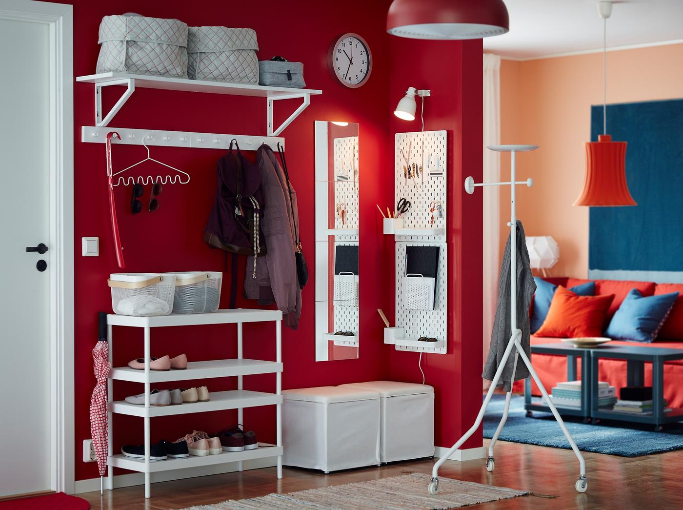 Combine the stackable MACKAPÄR shoe rack with a white wall shelf, footstool and peg board to provide a home for shoes, coats and smaller items in a small, open hallway. A red wall adds an extra warm welcome.