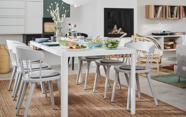 Combined living and dining room interior with fireplace, wall storage and a TINGBY dining table with OMTÄNKSAM chairs.